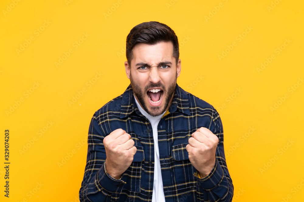 Young handsome man with beard over isolated yellow background frustrated by a bad situation Young handsome man with beard over isolated yellow background frustrated by a bad situation