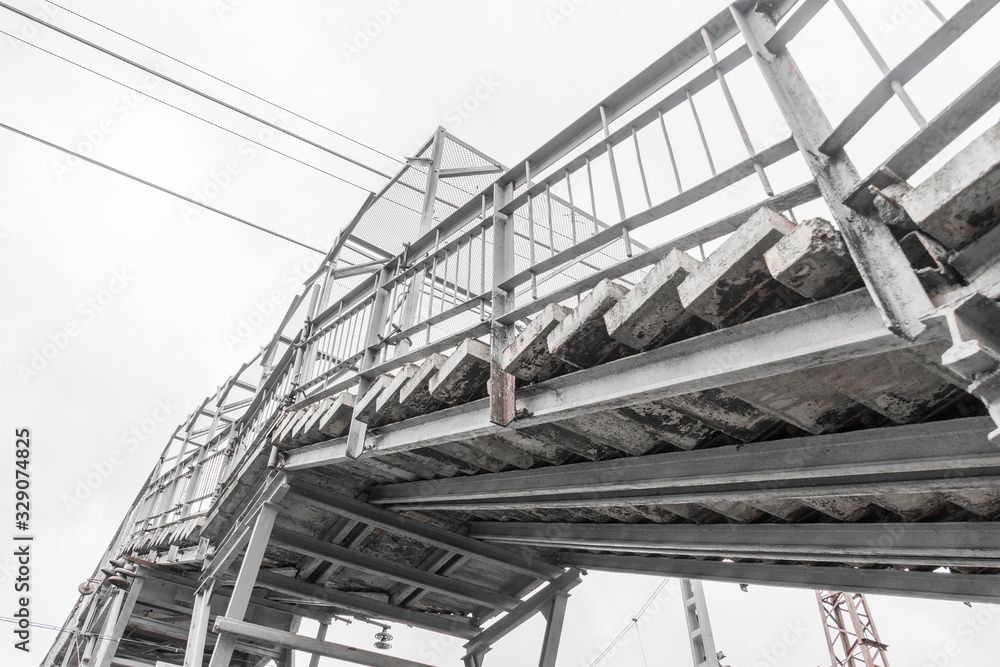 Stairs of pedestrian bridge over railway tracks. Bottom view. Technical structure for safe movement of people Stairs of pedestrian bridge over railway tracks. Bottom view. Technical structure for safe movement of people