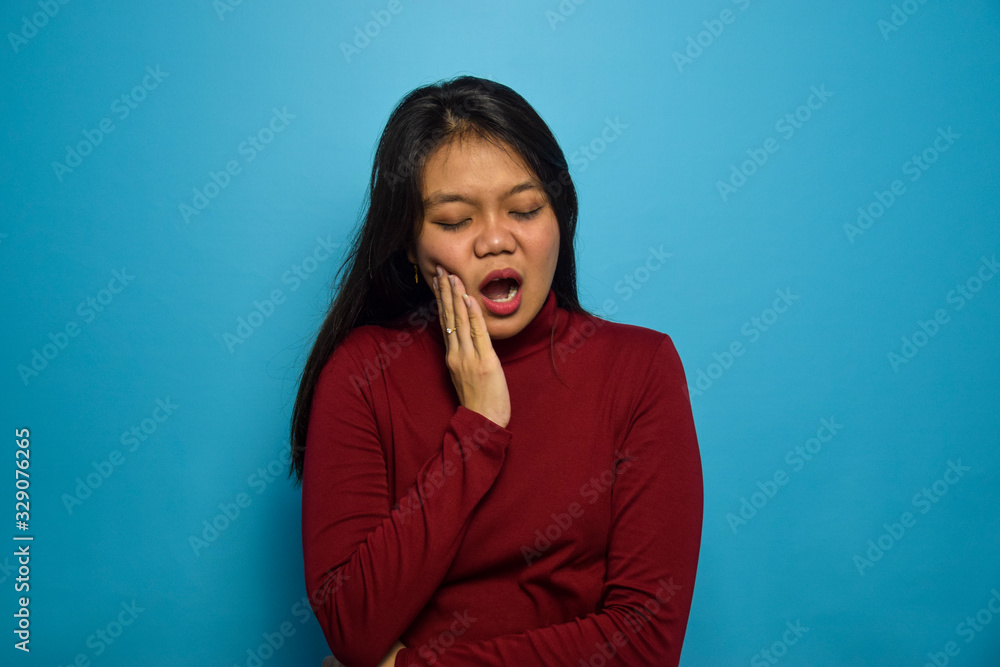 Portrait of Young beautiful asian women with blue isolated background, toothache gesture, Portrait of Young beautiful asian women with blue isolated background, toothache gesture,