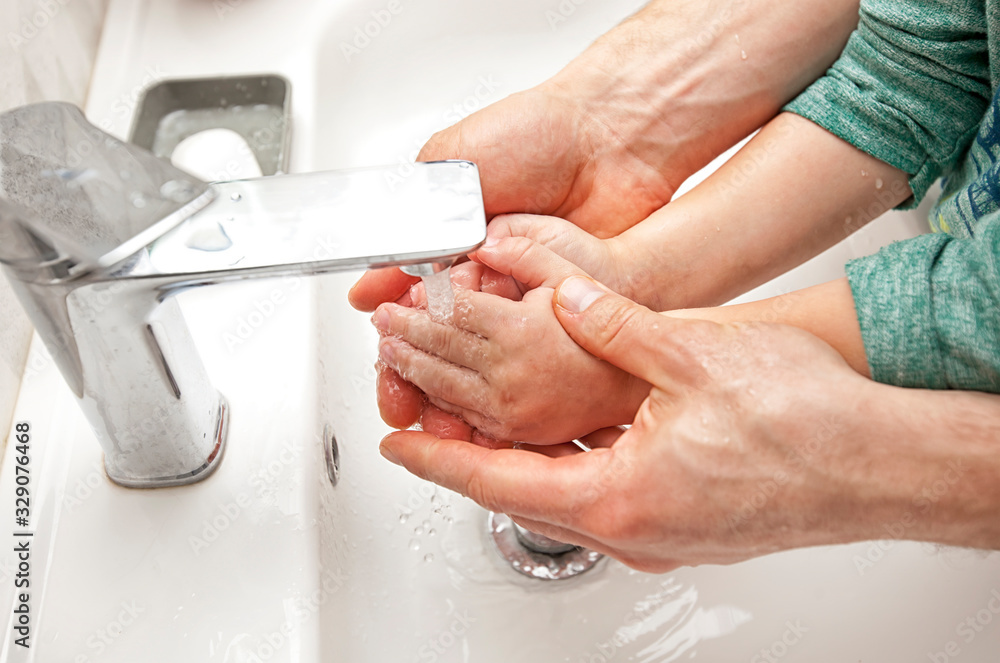 Father helps his son to wash his hands under the water Father helps his son to wash his hands under the water