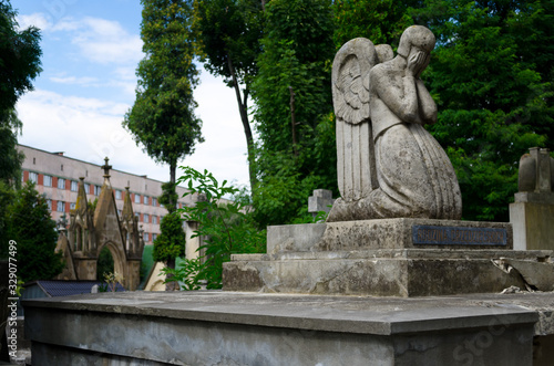 Ancient stone tombstone with a mourning angel. Lychakiv memorial cemetery in Lviv. An ancient Lutheran cemetery with statues and Gothic architecture. Lviv, Ukraine, July 19, 2018