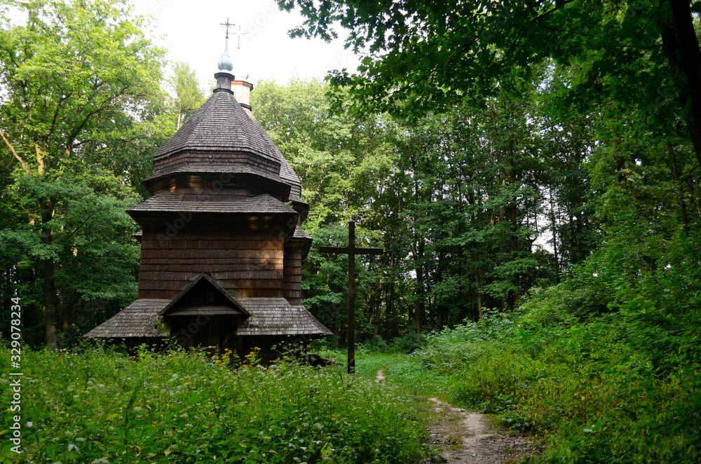 A green garden in the backyard with a wooden hut and lawn. Beautiful forest with a glade and a country house. Countryside lente housing, holiday home. Wooden Old Russian Architecture. A green garden in the backyard with a wooden hut and lawn. Beautiful forest with a glade and a country house. Countryside lente housing, holiday home. Wooden Old Russian Architecture.