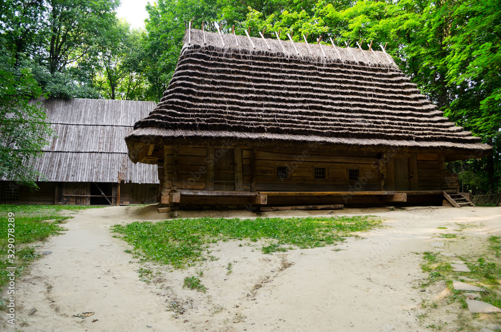 A green garden in the backyard with a wooden hut and lawn. Beautiful forest with a glade and a country house. Countryside lente housing, holiday home. Wooden Old Russian Architecture. A green garden in the backyard with a wooden hut and lawn. Beautiful forest with a glade and a country house. Countryside lente housing, holiday home. Wooden Old Russian Architecture.