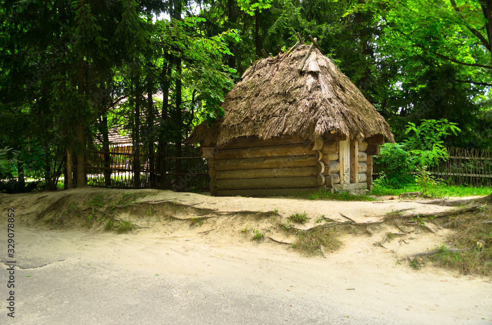 A green garden in the backyard with a wooden hut and lawn. Beautiful forest with a glade and a country house. Countryside lente housing, holiday home. Wooden Old Russian Architecture. A green garden in the backyard with a wooden hut and lawn. Beautiful forest with a glade and a country house. Countryside lente housing, holiday home. Wooden Old Russian Architecture.