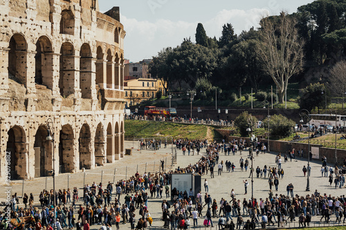 ROME, ITALY- MARCH 03, 2019: Ancient Roman Colosseum is one of main travel attractions. Nice view of Colosseum in spring sunny day. Many people walk past the Colosseum.