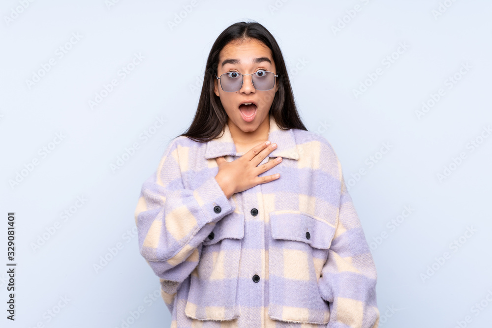Young Indian woman isolated on blue background surprised and shocked while looking right Young Indian woman isolated on blue background surprised and shocked while looking right