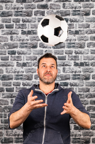 man plays with a ball against a stone background photo