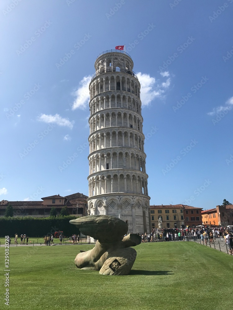 Panorama of a falling ancient tower surrounded by numerous tourists from all over the world.