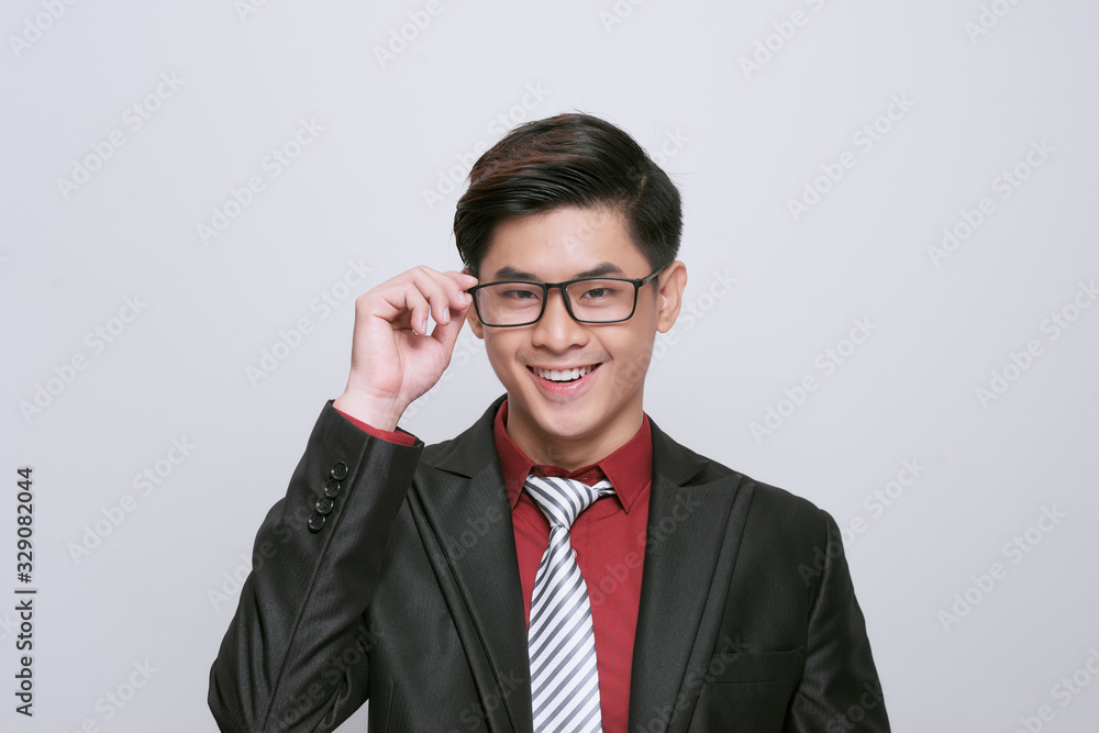 portrait of an attractive smart casual man fixing his glasses who is skeptical about something, standing on white background portrait of an attractive smart casual man fixing his glasses who is skeptical about something, standing on white background