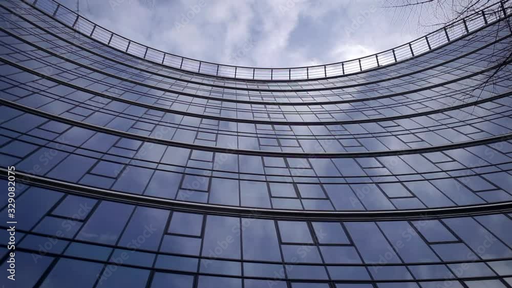 Time laps of an office building with reflection of clouds in glass windows. Reflection of clouds in a modern skyscraper. 