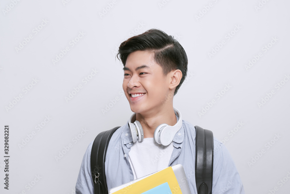 Portrait of young asian student holding books isolated over white background Portrait of young asian student holding books isolated over white background