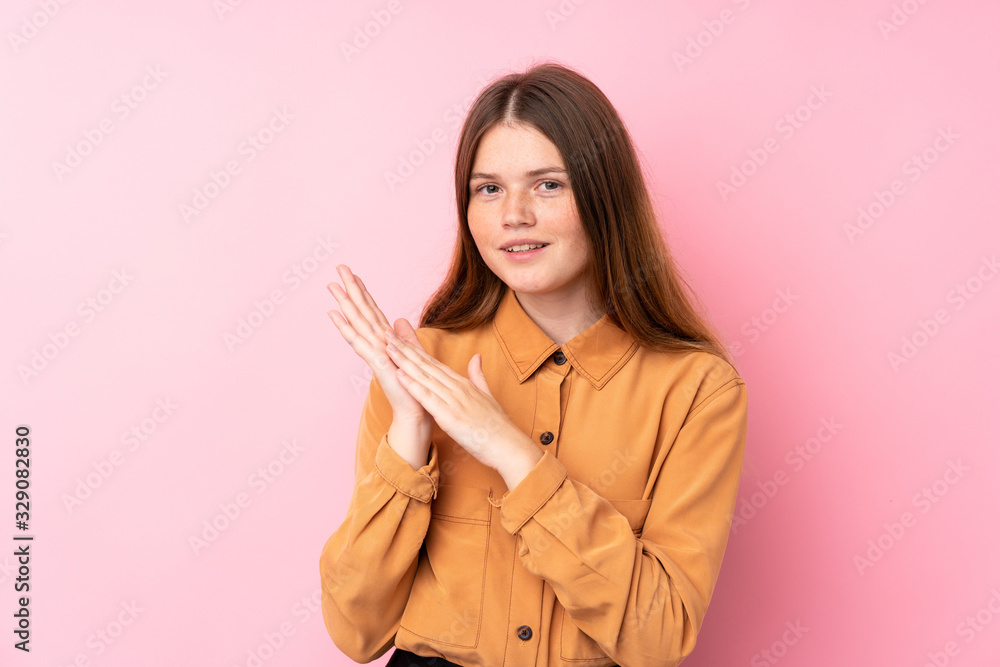 Ukrainian teenager girl over isolated pink background applauding after presentation in a conference
