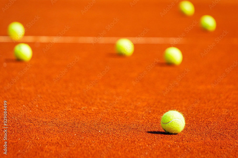 Yellow tennis balls on a clay court.