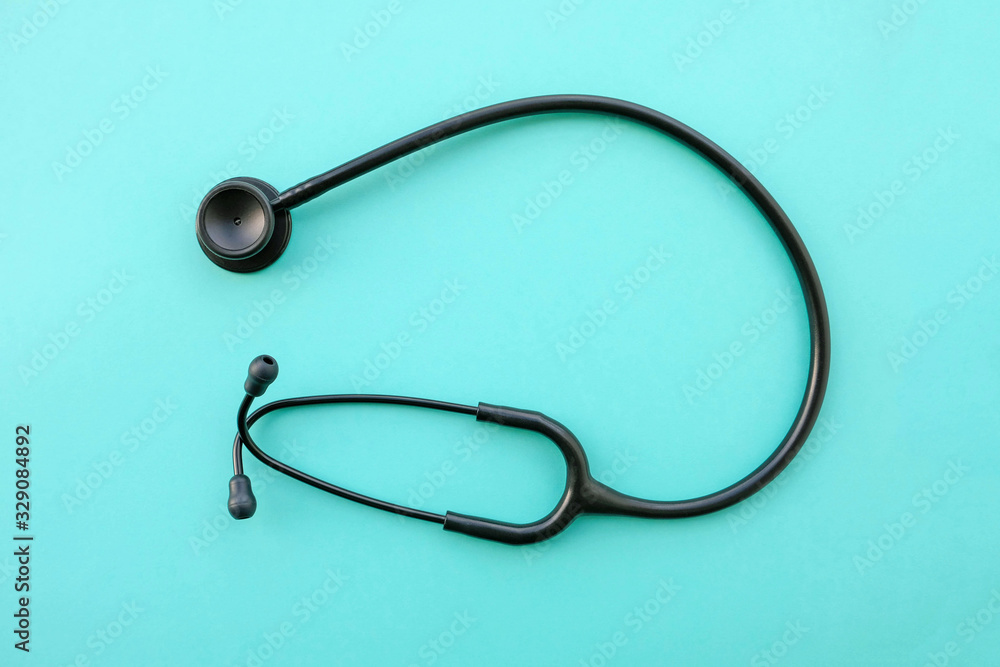 Black modern stethoscope on light blue background. Black modern stethoscope on light blue background.