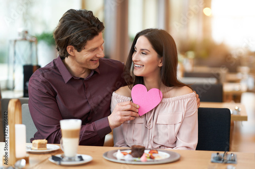 Young Couple Enjoying Coffee And Cake In Cafe