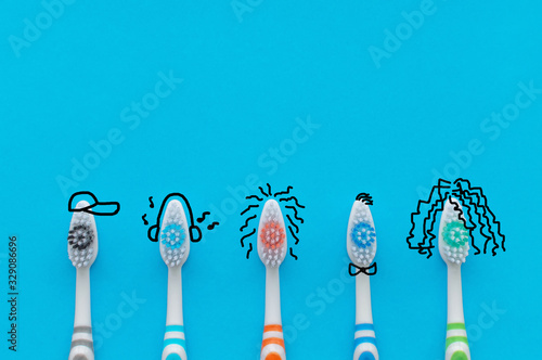 Colorful toothbrushes on a blue background in the form of cartoon characters. The view from the top. Close up. Concept of family hygiene.