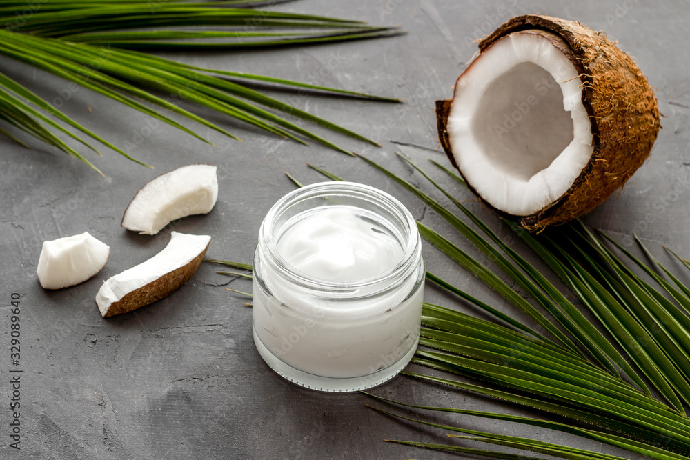 Face care. Coconut cream in glass jar on grey background Face care. Coconut cream in glass jar on grey background