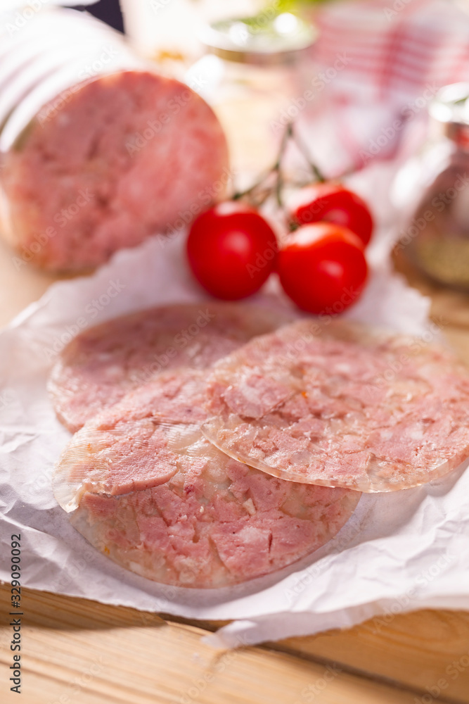 Sliced headcheese on a paper. Brawn. Pork cold cuts. Sliced headcheese on a paper. Brawn. Pork cold cuts.