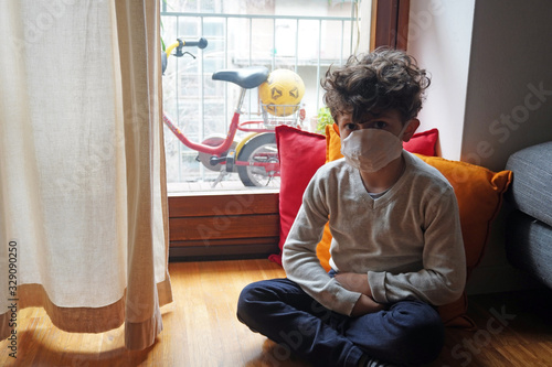 Milan - Quarantined child with mask, home life at home - Lombardy and Milan red zone - government measure in favor of the isolation of the areas infected by Coronavirus 2019 ncov9 ncov photo