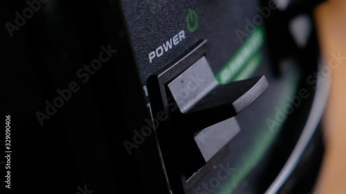 Somebody turn switch on the power button on an electrical device