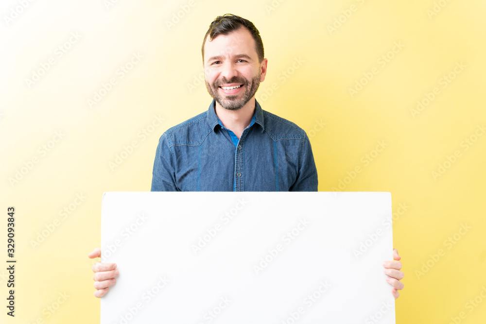 Happy Handsome Adult Man Is Holding White Poster Happy Handsome Adult Man Is Holding White Poster