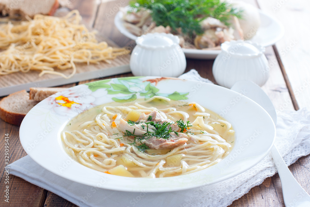 Homemade chicken soup with homemade egg noodles, horizontal Homemade chicken soup with homemade egg noodles, horizontal