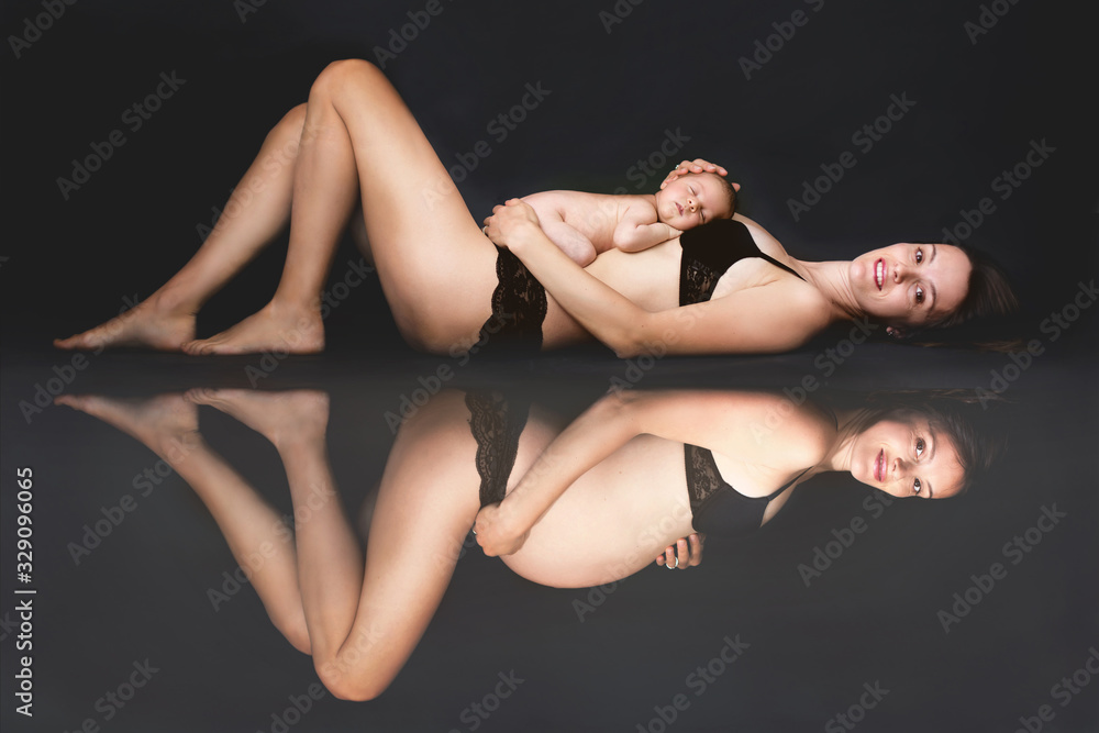 Portrait of Beautiful woman with newborn on her stomach and reflection of pregnant woman, isolated on black studio background Portrait of Beautiful woman with newborn on her stomach and reflection of pregnant woman, isolated on black studio background