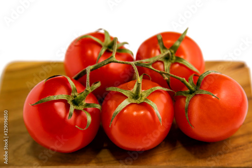 Tomatoes on a branch on a white background.