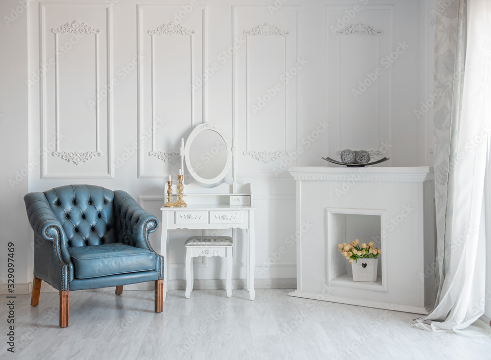 White room with blue retro chair and mirror.