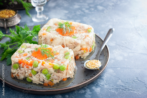 Homemade jelly with chicken, pork peas with slices of carrots, horizontal, copy space