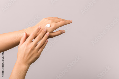 healthy hands of a young woman applying moisturizer. skincare concept beauty photoshoot