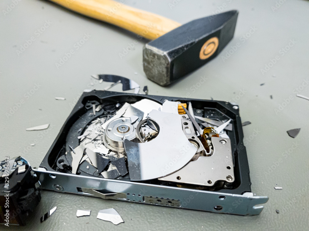 Destroying computer hard drive with a hammer.
