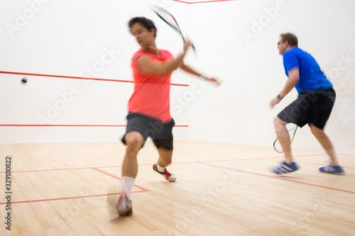 Squash players in action on a squash court (motion blurred image  color toned image) © lightpoet