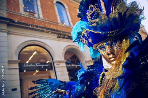 [Venice, San Marco square/Italy - feb. 2020] The anonimous person in the bright traditional fashionable Venice carnival costume with the mask