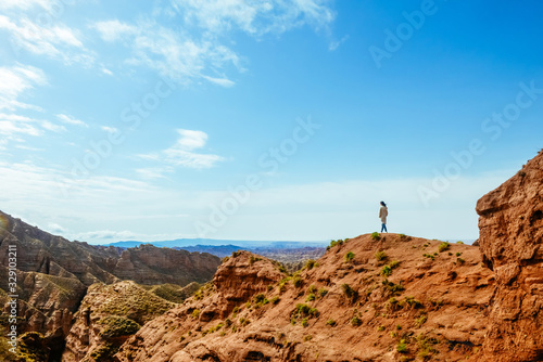 Young girl enjoys the view of valley on top of hill