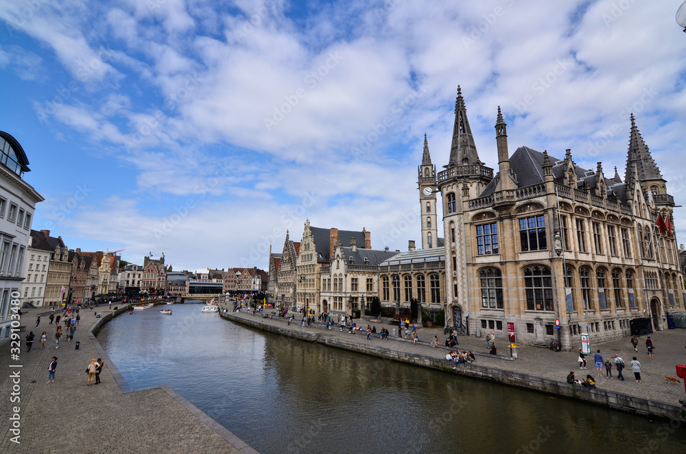 Obraz premium Ghent, Belgium, August 2019. Breathtaking cityscape: from the St. Michael's bridge to the street along the Graslei canal. One of the most beautiful postcards in the city. People stop to watch.