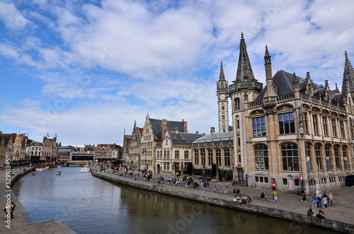 Ghent, Belgium, August 2019. Breathtaking cityscape: from the St. Michael's bridge to the street along the Graslei canal. One of the most beautiful postcards in the city. People stop to watch.