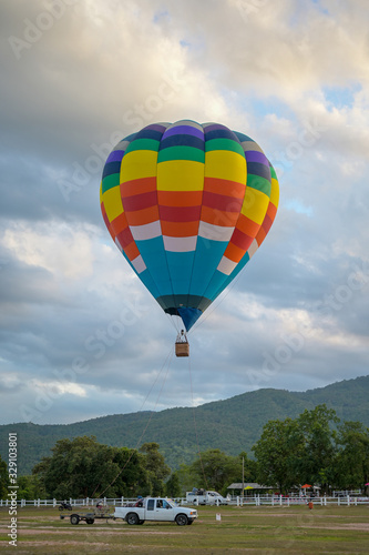 Coroful Hot Air Ballon Flying In The sky with clouds and mountain background