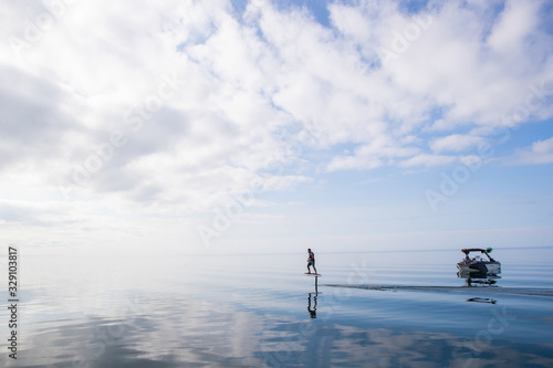 Obraz na płótnie Man riding an electric hydrofoil foil board on a lake with a life jacket w salonie