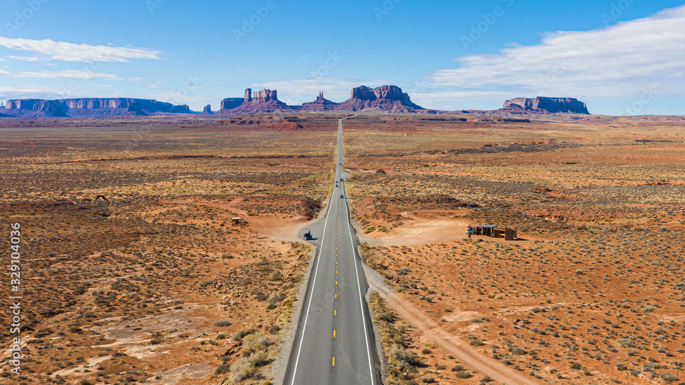 Obraz premium Aerial view of straight steet going towards the spectacular stone towers of Monument Valley in winter