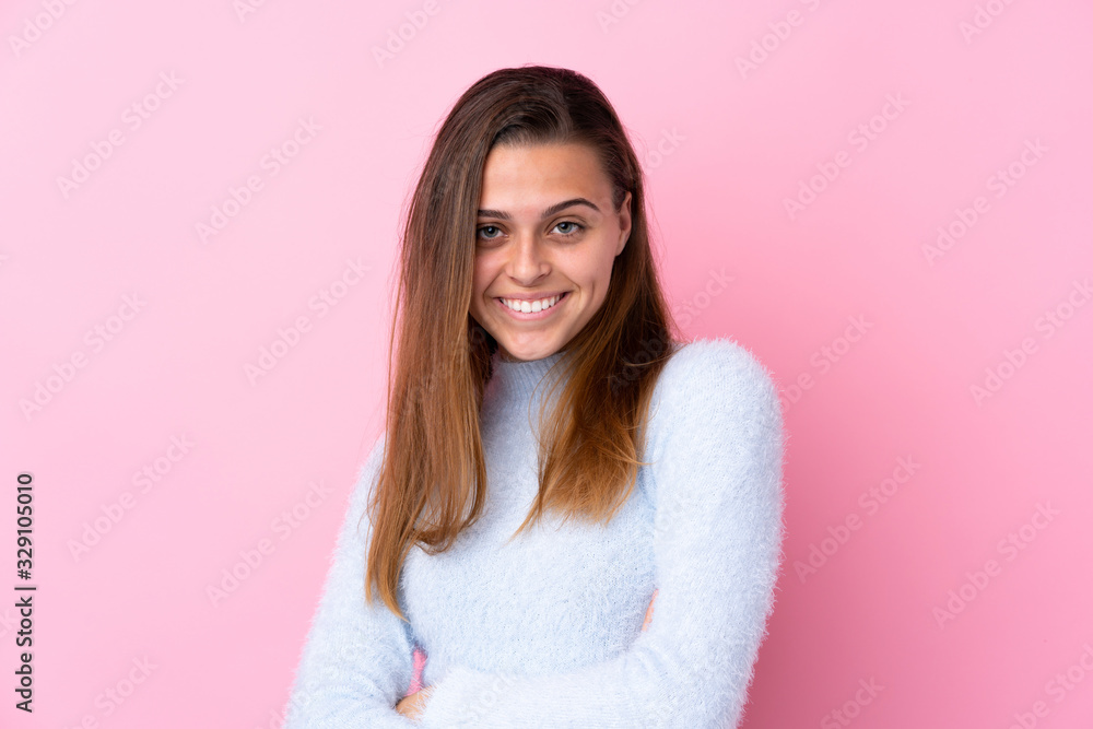 Fototapeta premium Teenager girl with blue sweater over isolated pink background laughing