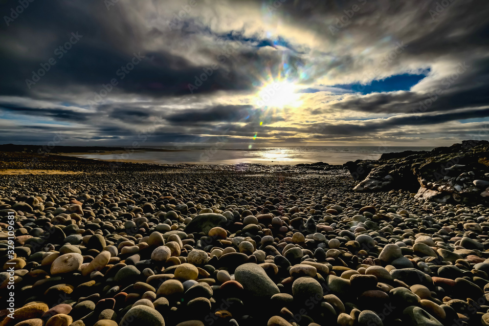Obraz premium Pebbles and Rocks on Pink Bay at Sunset