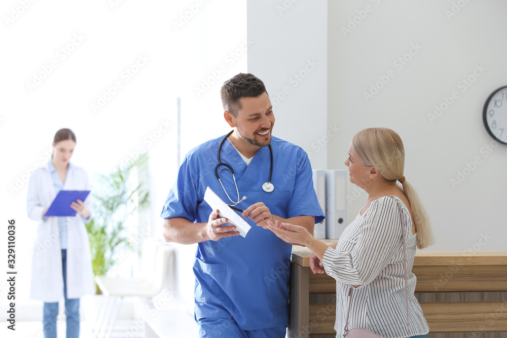 Obraz premium Doctor talking with patient in hospital hall