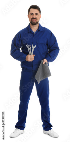 Full length portrait of professional auto mechanic with wrenches and rag on white background