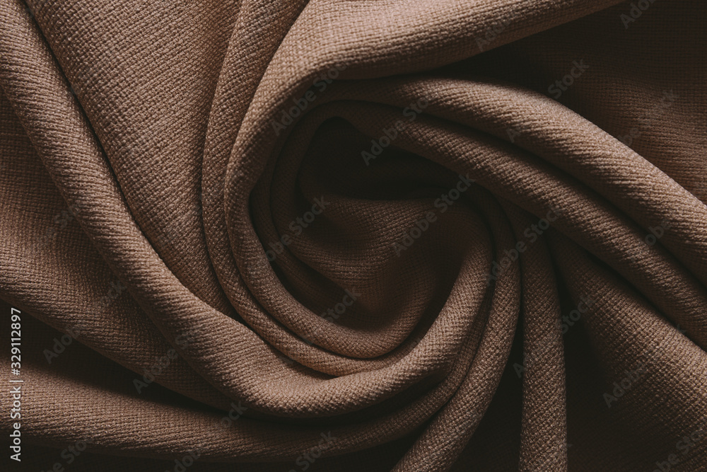 Jute beige linen on a table in natural light, folded, brown Jute beige linen on a table in natural light, folded, brown