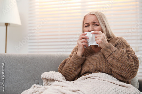Mature woman suffering from cold at home. Dangerous virus