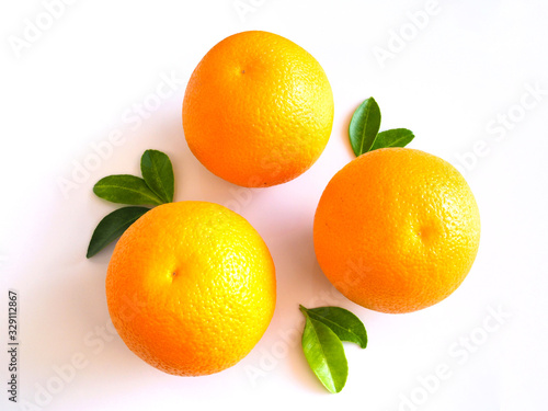 Bright yellow fresh citrus fruit oranges with green leaf isolated on white background.
