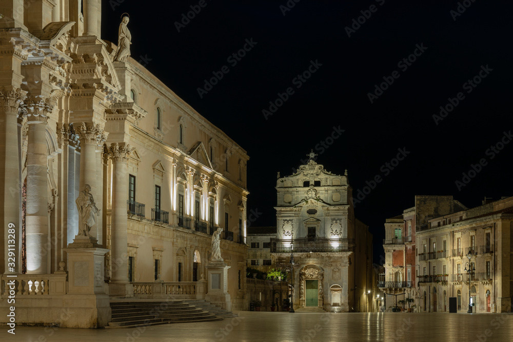 View of the main square (Piazza Duomo) of Ortygia island and facade of the catholic church of Saint Lucia alla Badia at night in Syracuse in Sicily