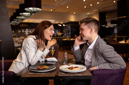 happy caucasian couple have dinner  dating in luxury restaurant. lady and guy enjoy spending time together. indoors