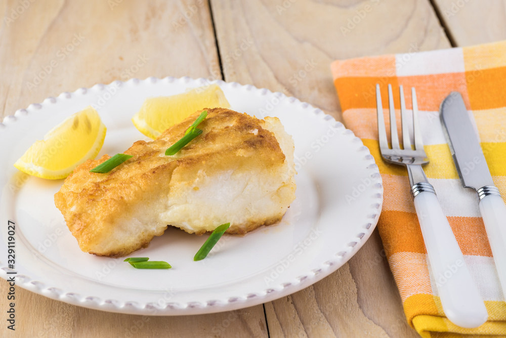 Fried light breaded cod fish.